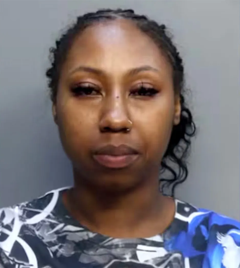 Mugshot of a woman with dark hair pulled back, wearing a patterned shirt.